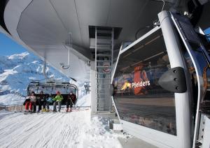 a group of people sitting on a ski lift at Residence Texel in Pfelders