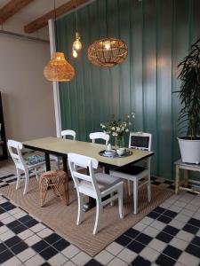 einen Esstisch mit weißen Stühlen und 2 Leuchten in der Unterkunft Het Pakhuis Schiedam in Schiedam
