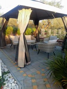 an umbrella on a patio with chairs and a table at Studio Apartman Vortex in Fažana