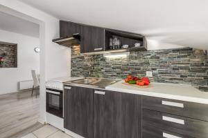 a kitchen with brown cabinets and a plate of vegetables at Bella Central apartment in Rijeka
