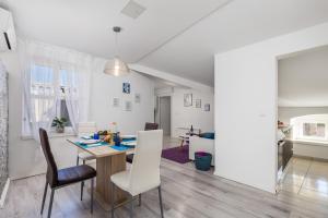 a dining room and living room with a table and chairs at Bella Central apartment in Rijeka