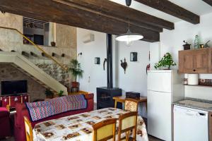 cocina y sala de estar con mesa y nevera en Casa del Hortelano, en Chinchón