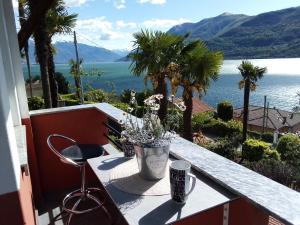 a table on a balcony with a view of the water at CA' DEL LAGO in Cannobio