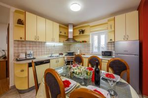 a kitchen with yellow cabinets and a table and chairs at Central Apartment Castle Cippico in Kaštela