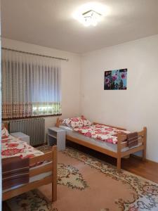 1 dormitorio con 2 camas y ventana en Visoko Homestay, en Visoko