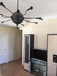 un soggiorno con TV e lampadario pendente di Old Town apartament a Šiauliai