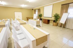 una sala conferenze con tavoli bianchi e sedie bianche di Tambati Overnight and Conference Center a Polokwane Altre 37 foto