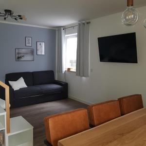 a living room with a couch and a flat screen tv at Petit Bagage 2019 Neueröffnung in Sankt Augustin
