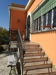 un conjunto de escaleras a una casa con un banco en b&b bellavista en Savona