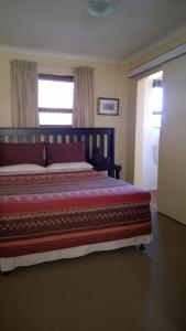 a bedroom with a large bed and a window at Baviana Beach Lodge in Jacobs Bay