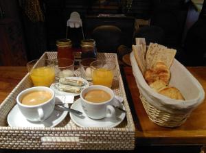 a tray with cups of coffee and pastries on a table at Hôtel Le Porquerollais in Porquerolles