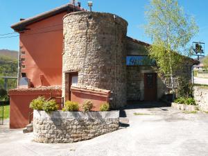 a building with a stone chimney on the side of it at Albergue La Torre in Santiurde de Reinosa