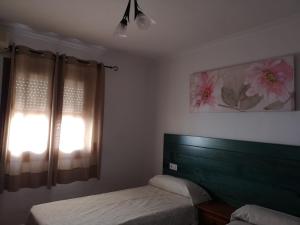 a bedroom with two beds and a window with curtains at Pensión Venta Julián HCA01134 in El Bosque