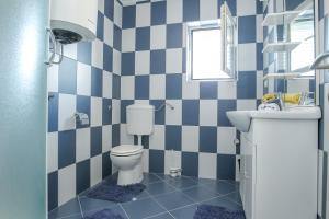 a blue and white bathroom with a toilet and a sink at SENITA's Rooms & Apartments in Nin +59 photos