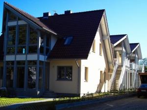 a white house with a black roof at FeWo an der Ostsee Nr. 2 in Rerik