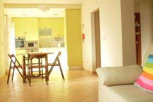 uma sala de estar com uma mesa e cadeiras e um sofá em Ericeira - Apartment with Patio - Horizonte Mar na Ericeira