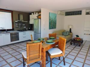 een keuken en een woonkamer met een houten tafel en stoelen bij Loris House in Massa Lubrense