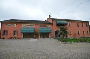 Legnaro的住宿－Agriturismo I Marzemini，一座红色的大建筑,上面有蓝色遮阳篷