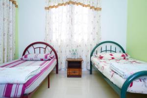 sypialnia z 2 łóżkami i stołem w obiekcie Anjung Nor Muslim Homestay w mieście Dungun