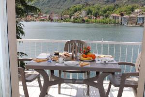 a table on a balcony with a view of the water at CASA DEL LAGO in Omegna