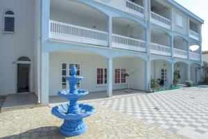 a blue fountain in front of a building at SENITA's Rooms & Apartments in Nin