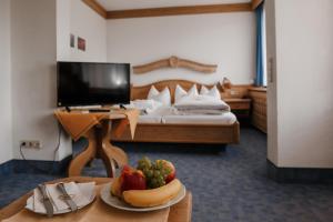 una habitación con una cama y una mesa con una bandeja de fruta en Hotel Vier Jahreszeiten, en Berchtesgaden