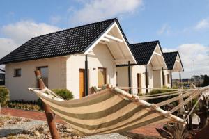 a hammock in front of a house at Domki DRAGON Łeba in Łeba
