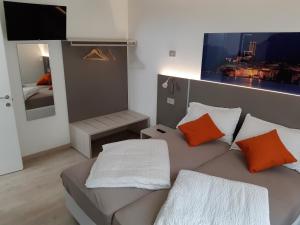 sala de estar con sofá y almohadas de color naranja y blanco en Cà alla Pòssa, en Malcesine
