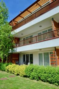 an apartment building with a balcony and bushes at Apartment Aurora in Moravske Toplice