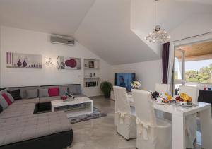 ein Wohnzimmer mit einem Sofa und einem Tisch in der Unterkunft Adriatic Dream Apartments in Dubrovnik