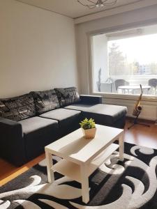 a living room with a couch and a coffee table at Home Away Holiday in Kuopio