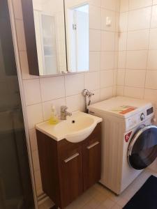 a bathroom with a sink and a washing machine at Home Away Holiday in Kuopio