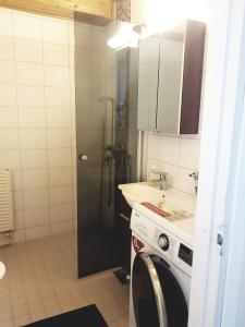 a bathroom with a shower and a sink and a washing machine at Home Away Holiday in Kuopio