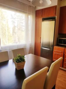 uma cozinha com uma mesa com cadeiras e um frigorífico em Home Away Holiday em Kuopio