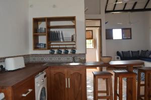 a kitchen with a counter top and a dishwasher at Dragonfly Cottage - Courtyard Garden 3 Bedrooms in Bagamoyo +15 photos