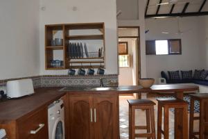 a kitchen with a counter top and a dishwasher at Dragonfly Cottage in Bagamoyo +8 photos