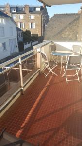 uma varanda com uma mesa e cadeiras num telhado em Très bel appartement centre ville 2 mn plages et marché em Dinard