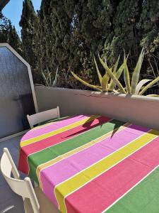 una mesa con un colorido mantel sentado en un patio en La Lampara Apartment en Aci Castello