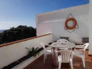 un patio con tavolo e sedie sul balcone. di Farol da Vila a Vila Franca do Campo