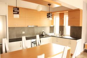 een keuken met een houten tafel en een eetkamer bij Alexandra´s Apartments in Sarandë