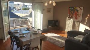 a living room with a table and a couch at Très bel appartement centre ville 2 mn plages et marché in Dinard