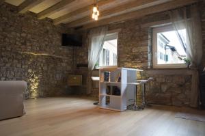 a living room with a stone wall and a book shelf at L'angolo di Filippo I piano in Cividale del Friuli