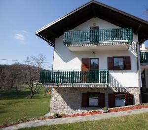 a house with a balcony on top of it at Apartment Gaia in Lokve