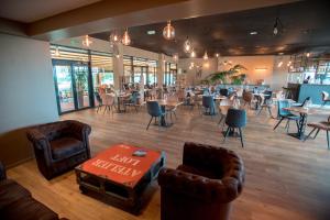 un restaurant avec des chaises et des tables ainsi qu'un bar dans l'établissement Hôtel et SPA du Château, à Lagord