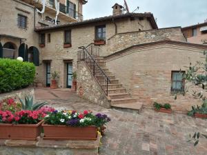 a stone building with stairs and flowers in front of it at Il Pozzo Di Sant'Andrea in Siena