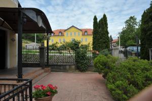 a yellow house with a fence in front of it at Hotel Puntijar in Zagreb