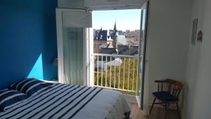 a bedroom with a bed and a large window at Très bel appartement centre ville 2 mn plages et marché in Dinard