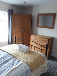 a bedroom with a bed with a dresser and a mirror at Lincoln lets 23 in Lincoln