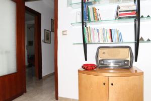 una pequeña televisión en la parte superior de un armario de madera en Casa Antonellina en Nápoles