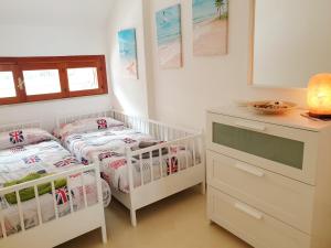 een slaapkamer met 2 aparte bedden en een dressoir bij La casa del sole sorgente in Letojanni